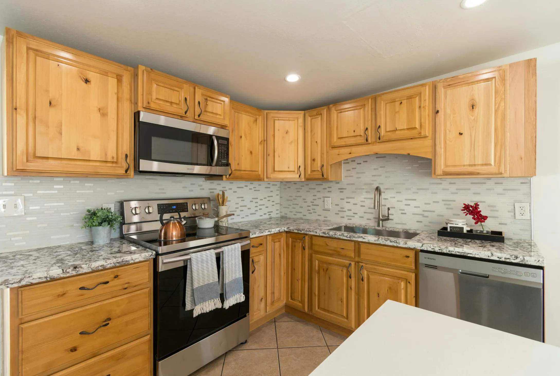 Under-sink cabinet with the doors open, showing supply lines on an exterior wall with minimal insulation.