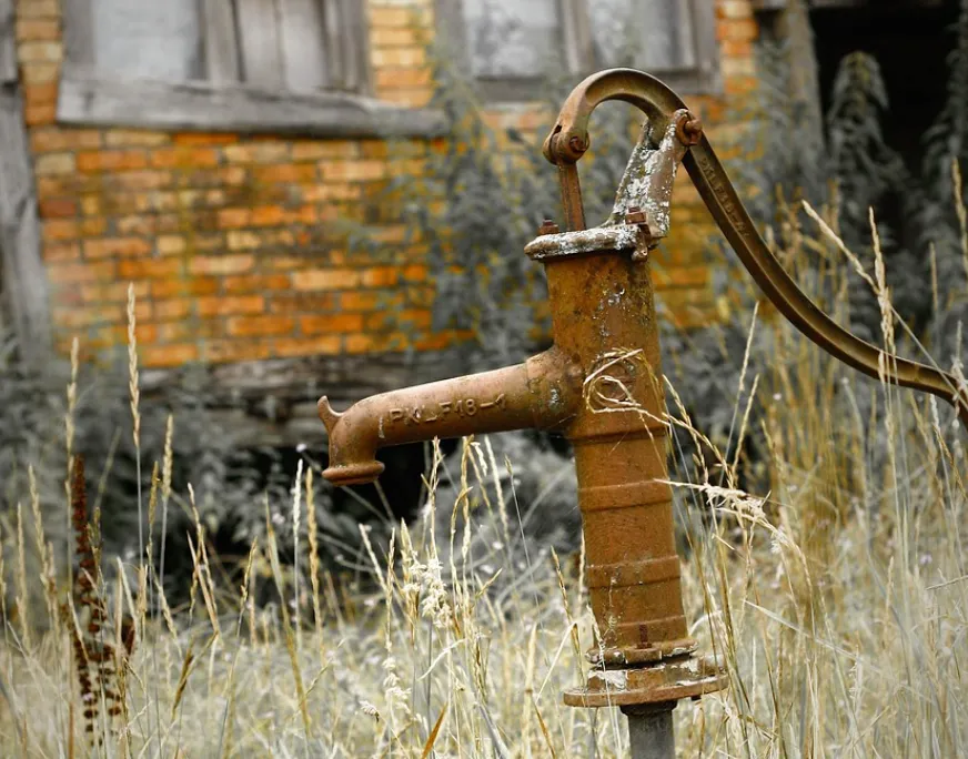 A licensed plumber in Roseville inspecting pipes under a kitchen sink in a bright, modern home