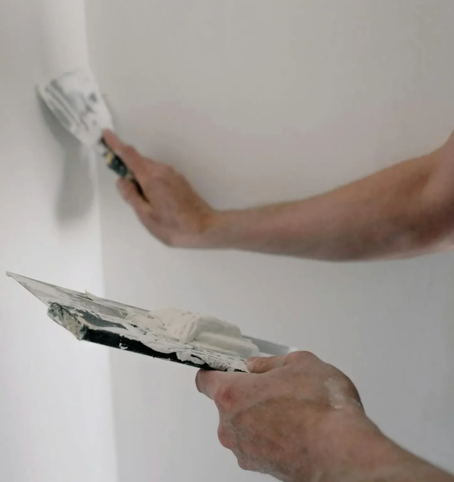 Split-screen illustration: on the left, multiple wall patches from past leak repairs; on the right, clean walls with a new, neatly labeled plumbing manifold.