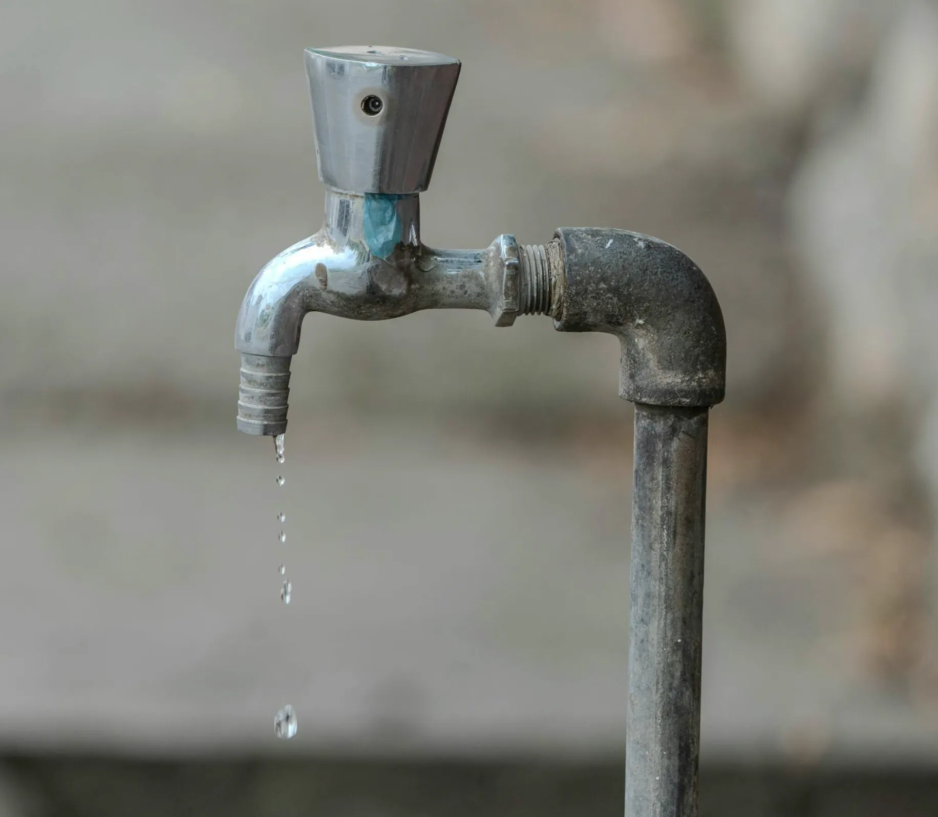 Close-up comparison of old corroded copper and galvanized pipes next to new PEX and copper lines resting on a workbench.